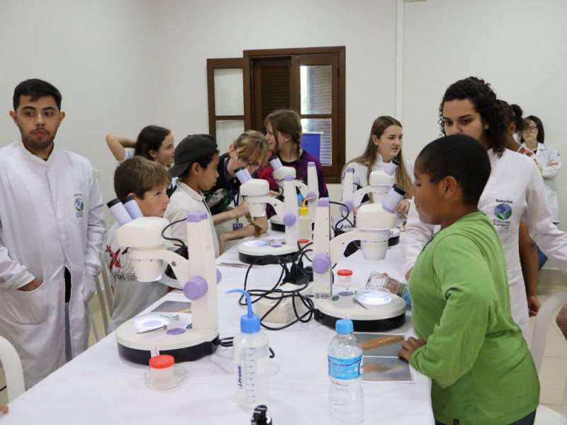 Estudantes no laboratrio manuseando microscpios, parceria com a Uniju
